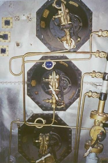 Close vertical view of several fuel oil burner assemblies and burner registers on the boiler front