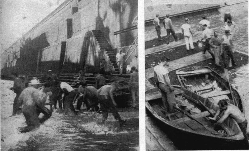 Workers using dip nets in dry dock