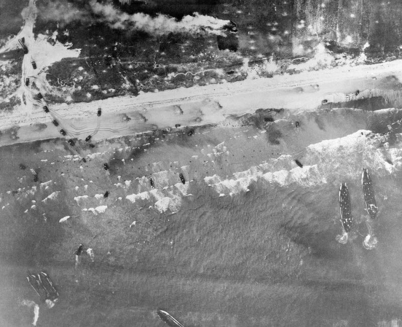 Men and assault vehicles storm Normandy Beach