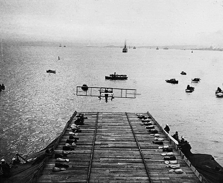 Ely's Curtiss pusher airplane off the deck of USS Birmingham, just before briefly touching the water and recovering to a successful landing at Willoughby Spit