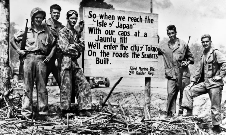 Marines at the famous sign reading On the roads the Seabees Built