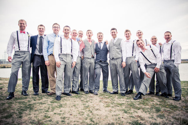 The groomsmen in shirtsleeves and suspenders, laughing together before the wedding