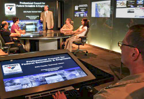 Overview of the Navy Command Center of the Future showing glass walls and video screens