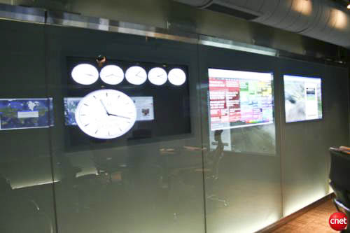 Glass walls on both sides of the command center with multiple video display screens