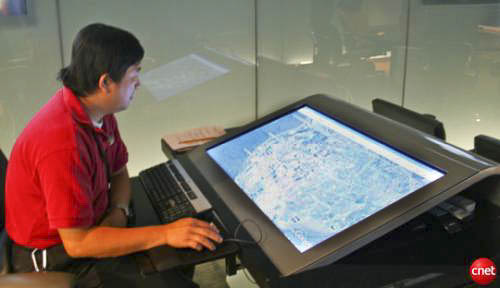 Table display in the foreground of the command center, monitored continuously by Navy personnel