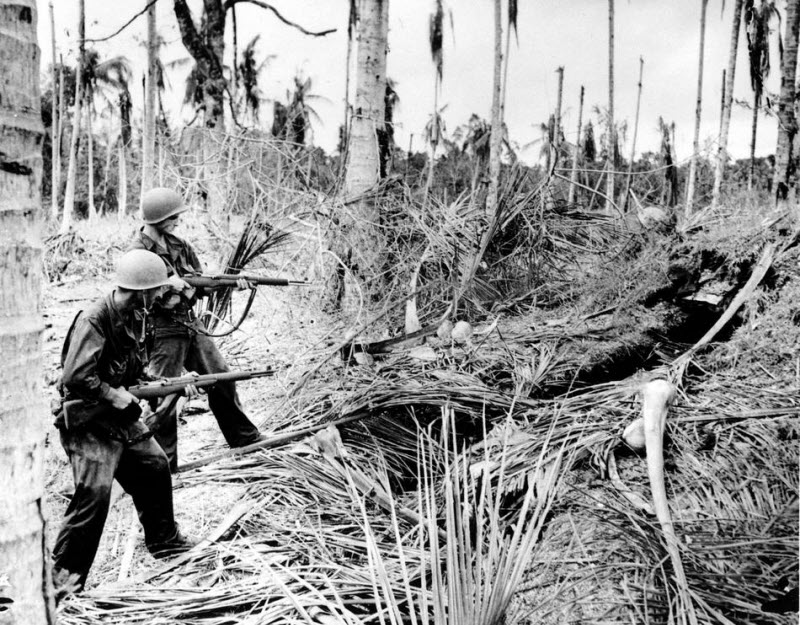 American soldiers fire into Japanese dugout at Buna New Guinea January 1943