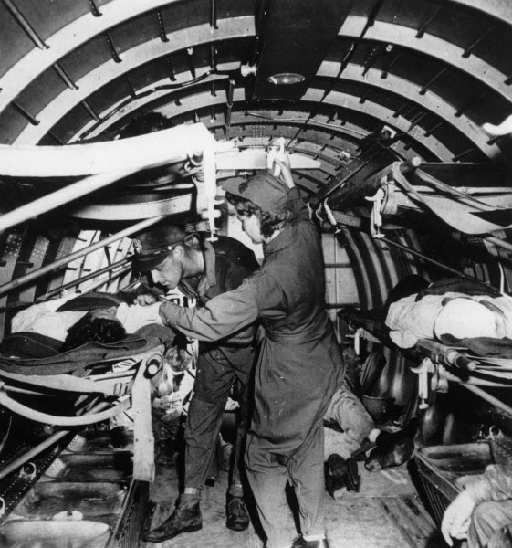 Wounded US Marine receives plasma transfusion from nurse Mae Olson above Guadalcanal June 1943