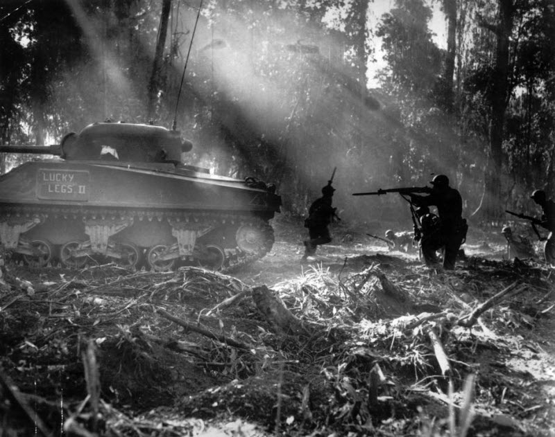 American infantrymen follow tank to secure area on Bougainville after Japanese infiltration March 1944