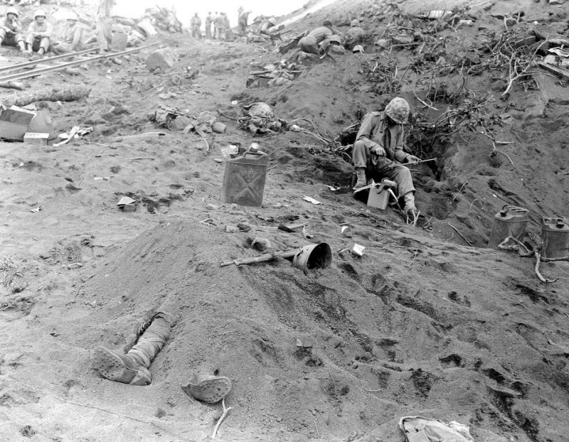 Feet of dead Japanese soldier protrude from mound of earth on Iwo Jima February 1945