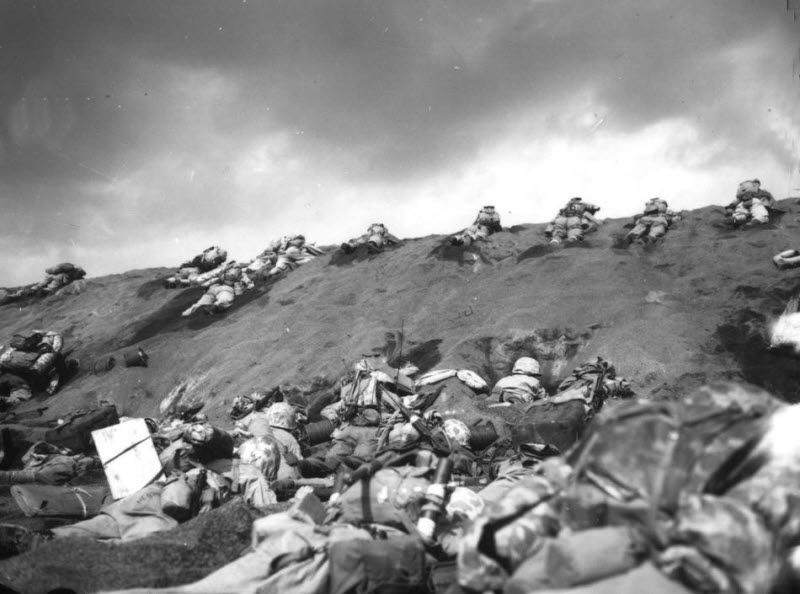 US Marines of 5th Division inch up sand dune on Red Beach toward Mount Suribachi Iwo Jima February 1945