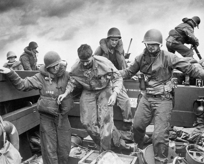 Wounded Marine transferred by Coast Guardsmen to landing craft off Iwo Jima February 1945